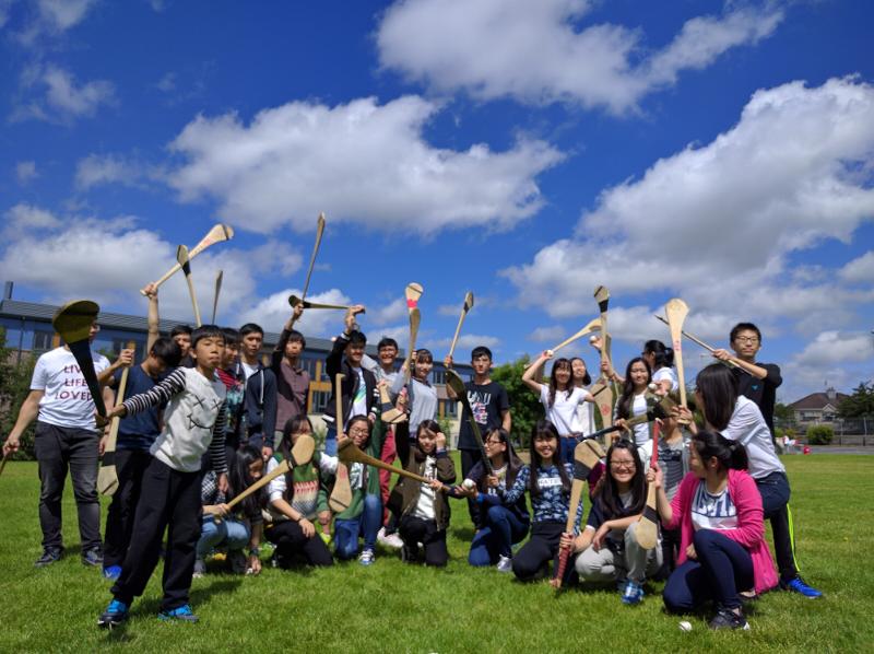 Grupo de jovens com sticks de hurling durante uma atividade num curso de ingles na irlanda.
