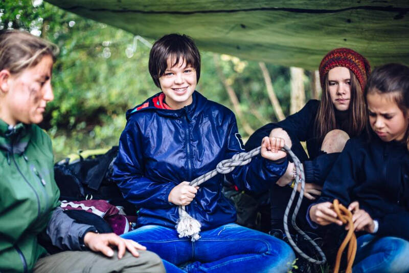 Meninas a aprender os nós no campo de férias de aventura