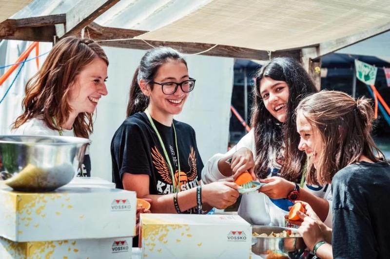 Jovens a divertirem-se durante a preparação da refeição ao ar livre no campo de férias Cartaxo