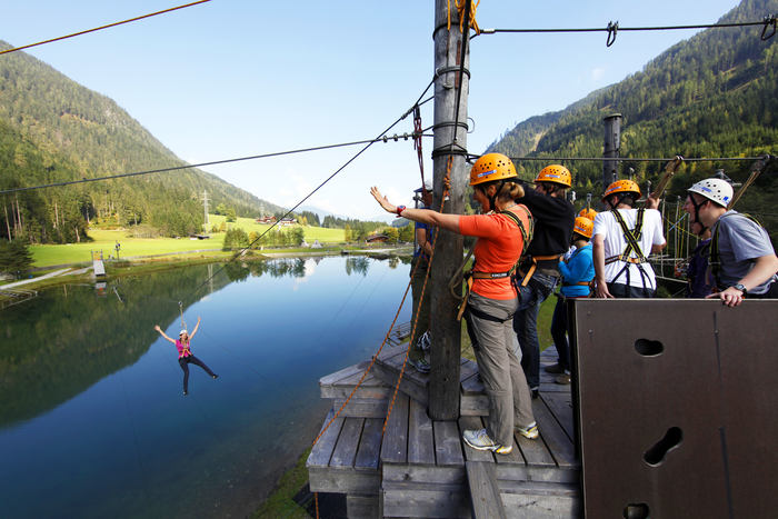 Jovem a fazer slide no lago durante o campo de férias na Áustria