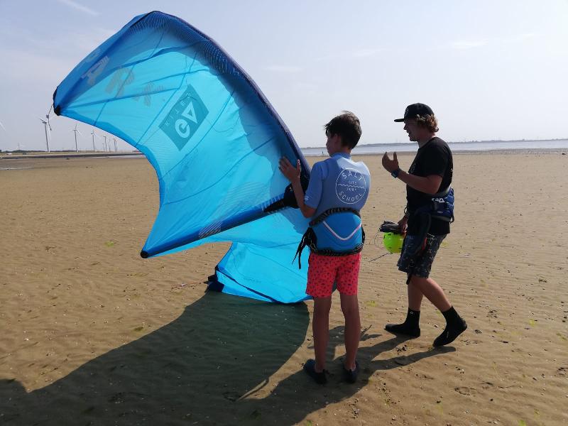 Instrutor a explicar ao jovem na praia as regras da atividade aquática do campo de férias