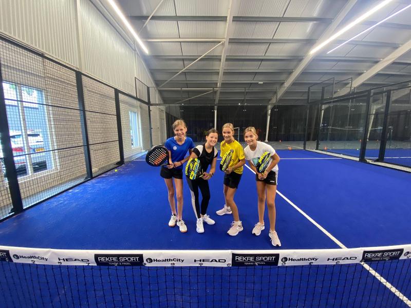 4 meninas em posição de jogo no campo de férias ténis