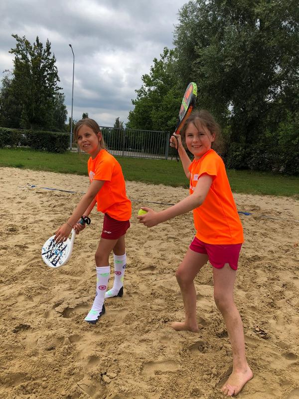duas meninas a jogarem paddle no campo exterior no surfcamp algarve