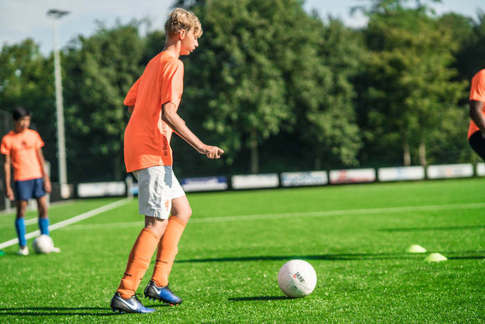 rapaz a fazer aquecimento no treino de futebol no surfcamp algarve