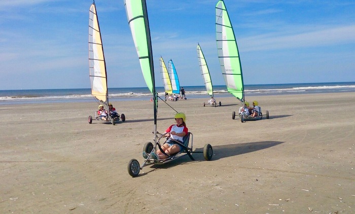 menina anda de kart à vela numa praia grande no curso de línguas