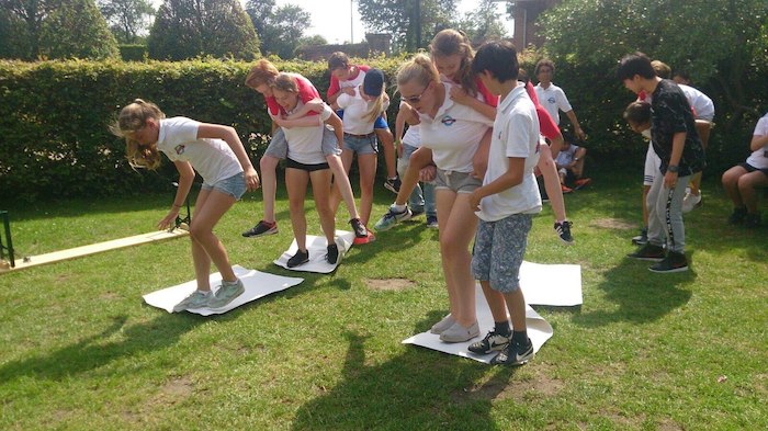Jogo de equipa no jardim com vários jovens e crianças num momento de diversão