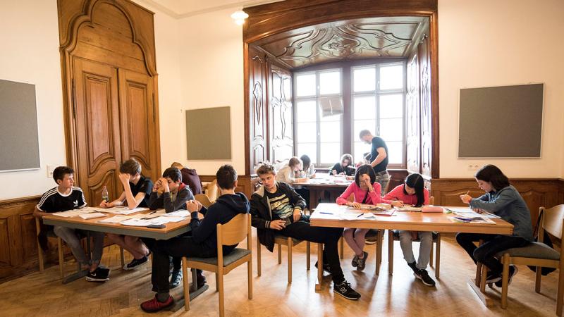 Participantes divididos em grupos na sala de estudo do curso de inglês de Verão