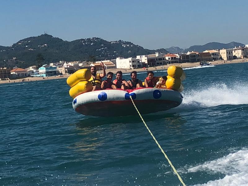 Jovens na bóia enquanto fazem atividade aquática em equipa no surf camp algarve