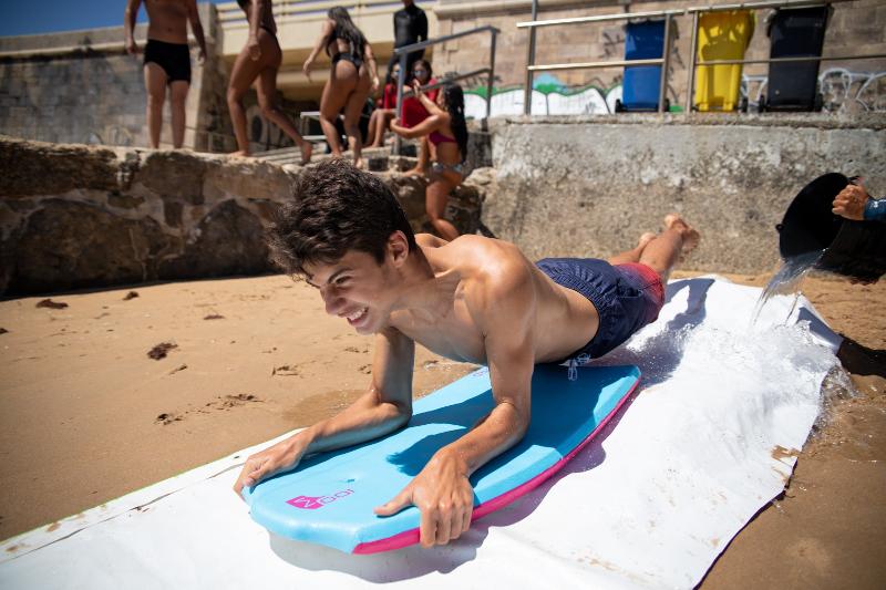 rapaz em cima de uma prancha de bodyboard a descer escorrega de água no surf camp lisboa