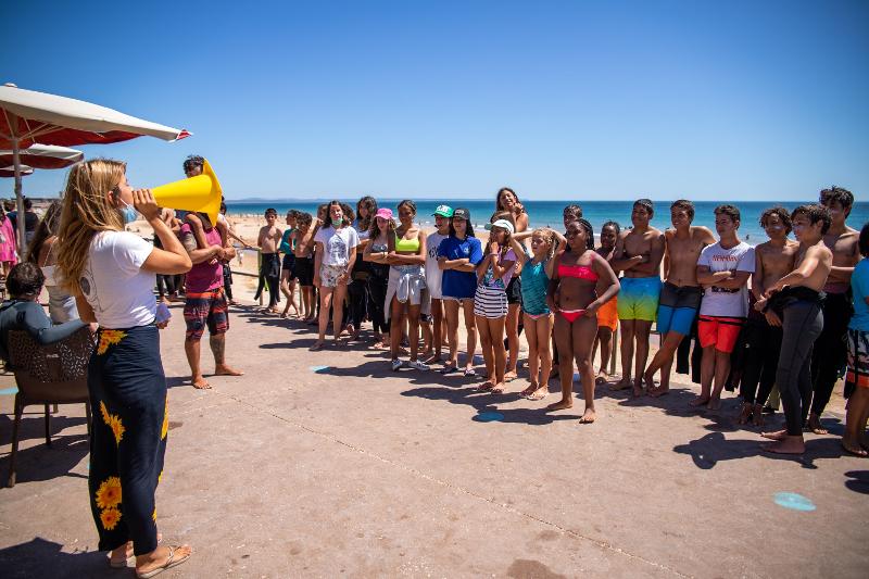monitora a dar indicações antes do início das atividades no campo de férias surf Carcavelos