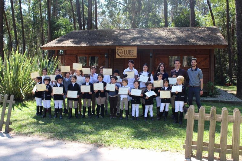 Foto de grupo das crianças no campo de férias de equitação com o certificado de participação