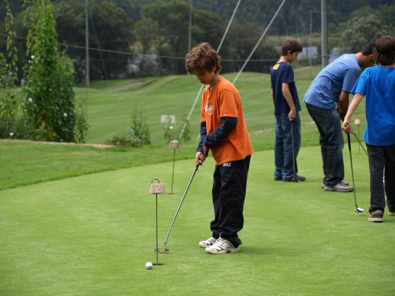 Crianças a praticar golfe durante o campo de férias de equitação em Portugal