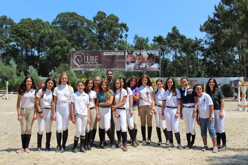 Grupo de meninas do campo de férias de equitação no picadeiro depois da atividade