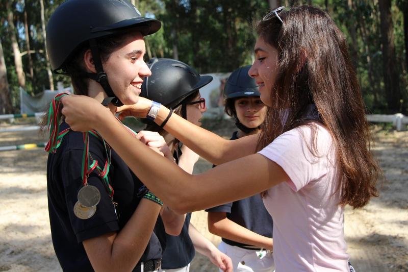 Crianças a receber as medalhas de participação no campo de férias de equitação