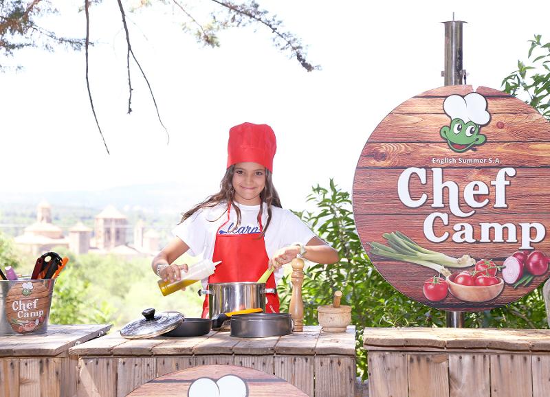 Menina a cozinhar no Chef Camp da colónia de férias no exterior