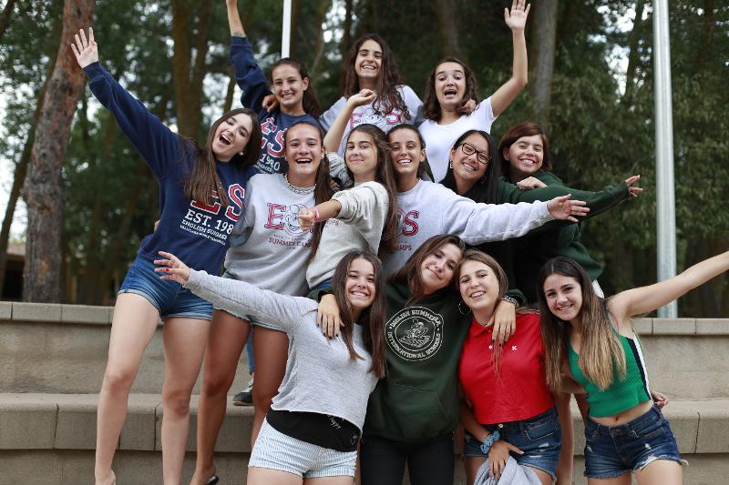 Grupo de participantes adolescentes na colónia de férias a pousar para a foto de grupo no anfiteatro
