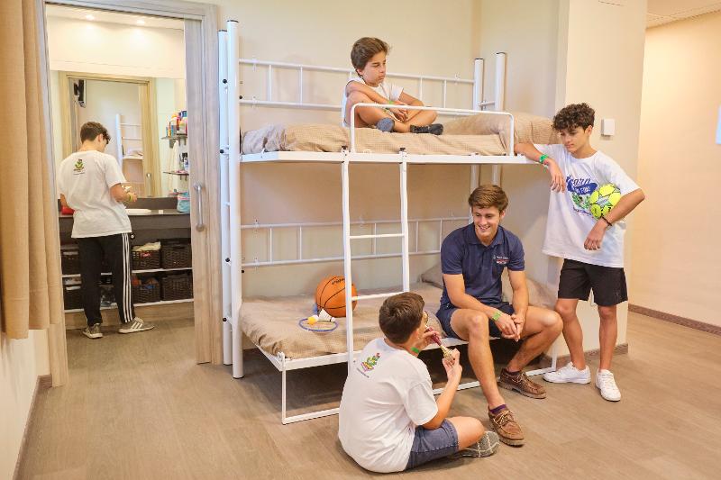 Crianças no quarto partilhado do colonias de ferias para aprender ingles a conversar durante o tempo livre