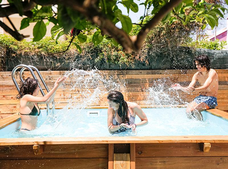 jovens na piscina a atirar água uns aos outros no campo de férias Surf