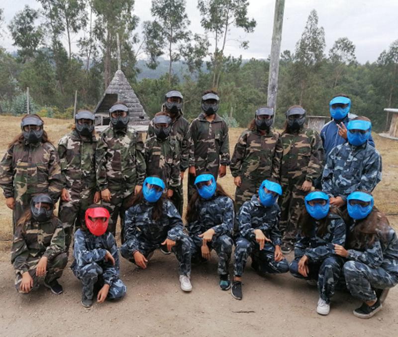 Grupo de participantes equipados antes do jogo de paintball do campo de férias norte
