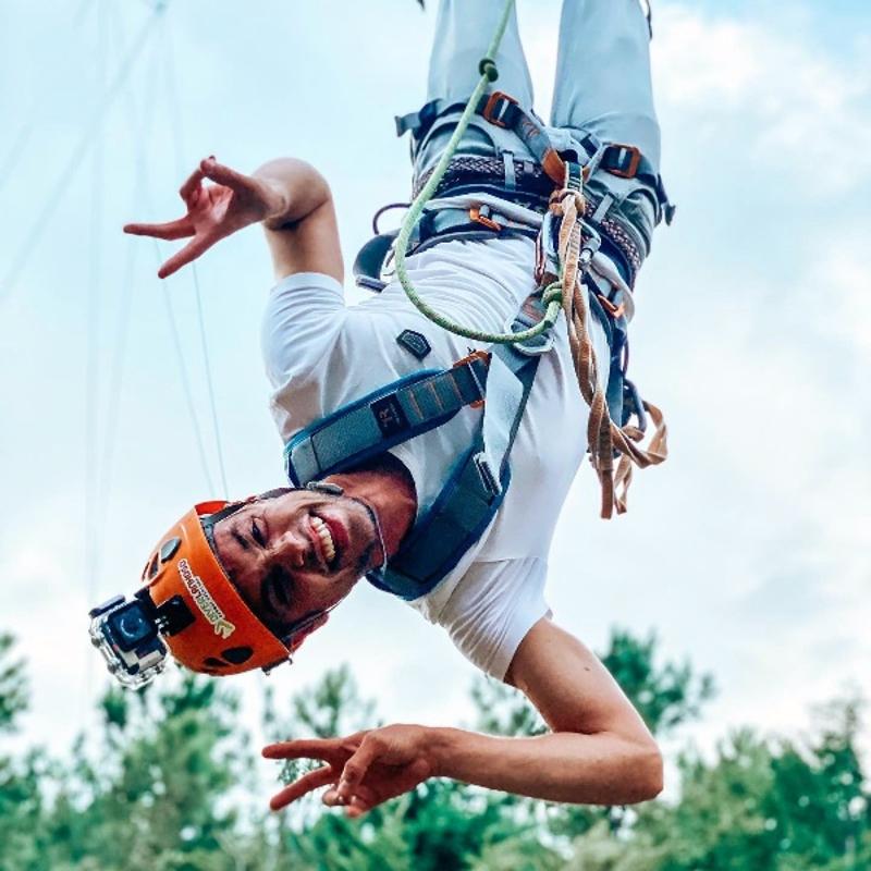 animador a sorrir para a foto enquanto faz bungee jumping no campo de férias militar