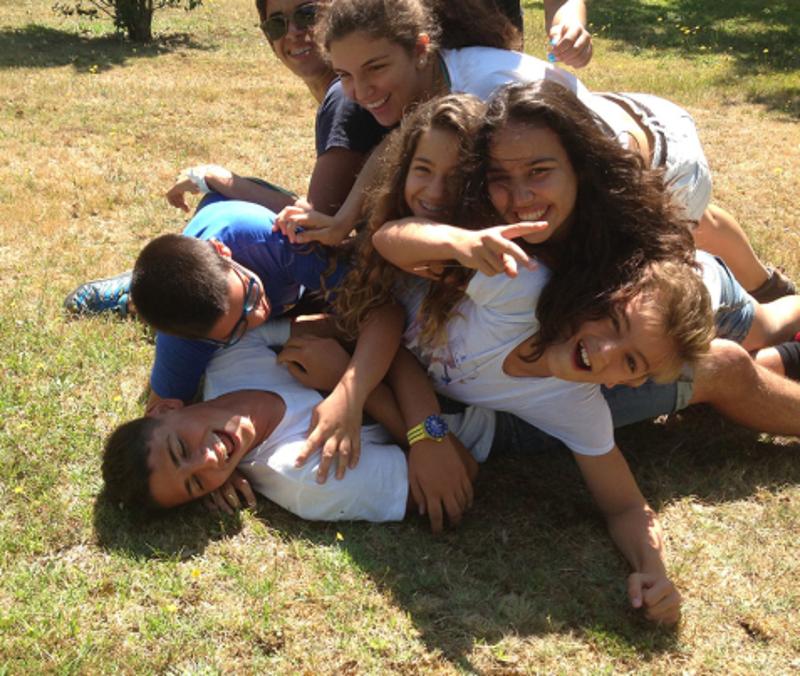 Jovens a brincar na relva durante o campo de férias de aventura no Norte de Portugal