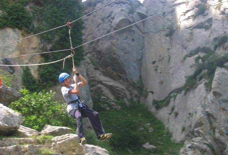 Jovem participante a fazer a atividade de slide durante o campo de férias