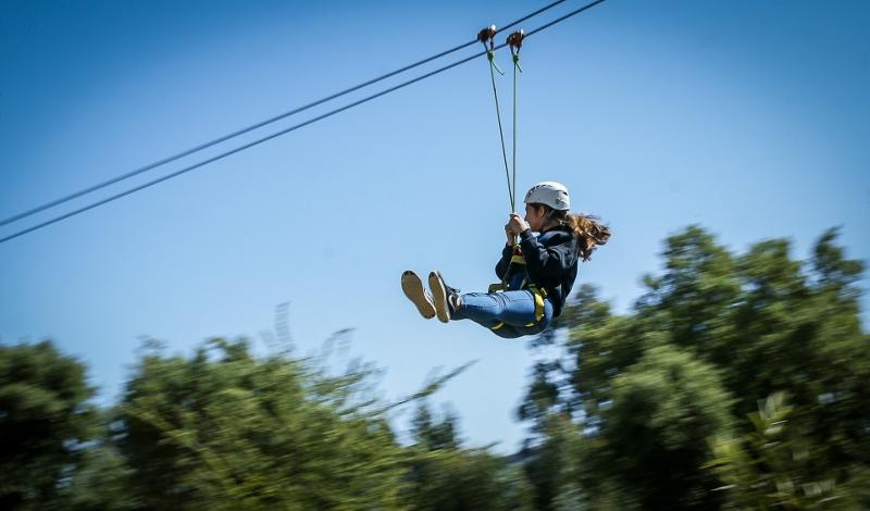 Criança a fazer a atividade de slide do campo de férias