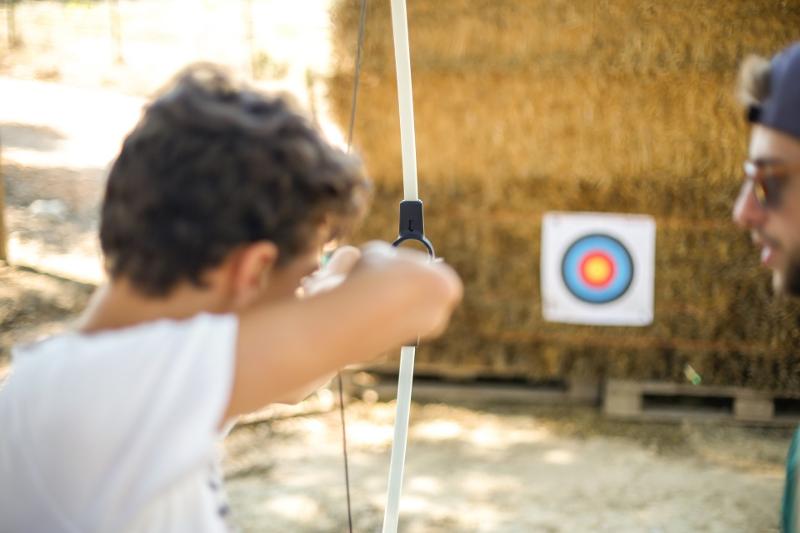  Jovem a praticar a atividade de tiro com arco sob a supervisão do monitor do campo de férias vendas novas