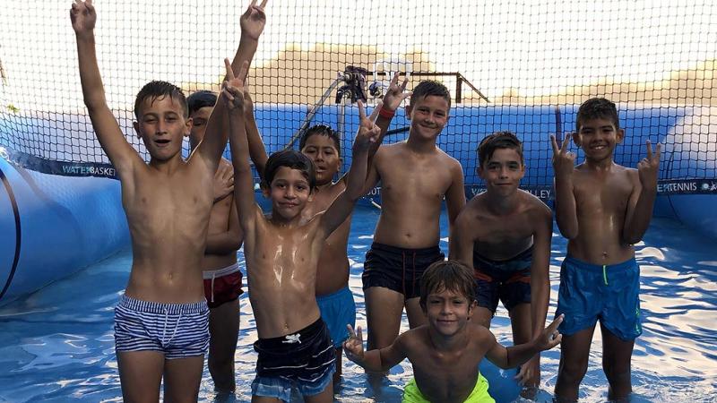 Crianças do campo de férias de futebol Lisboa a fazer atividade de voleibol na piscina