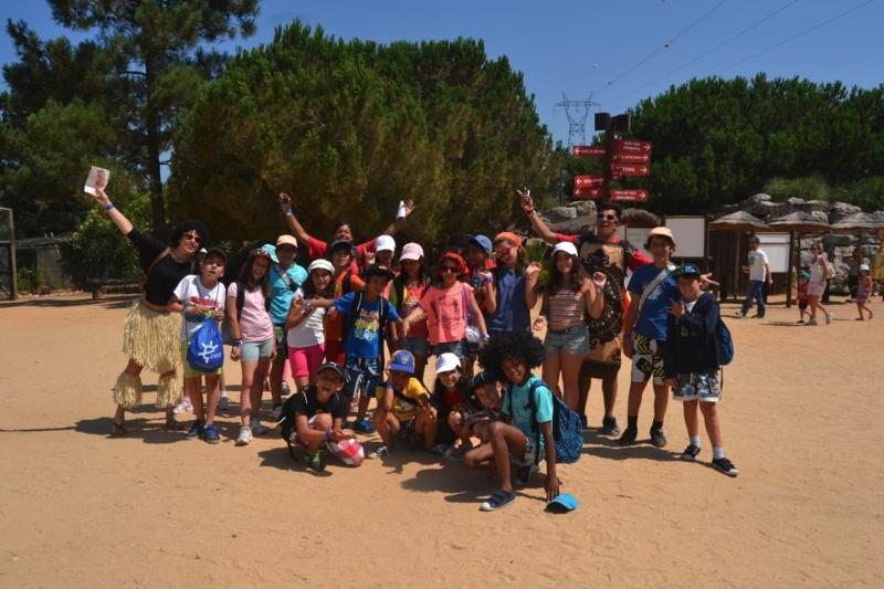 Crianças em visita ao parque durante o campo de férias a pousar para a foto de grupo