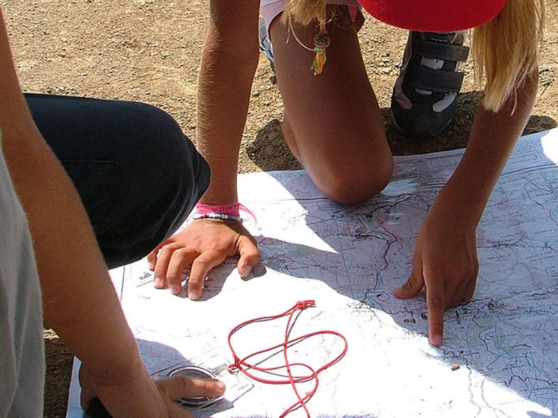 menina a ler o mapa durante atividade de orientação no campo de férias Lisboa