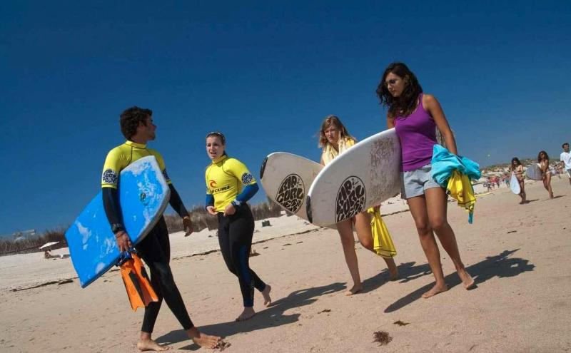 Participantes com a prancha na atividade de surf no campo de férias