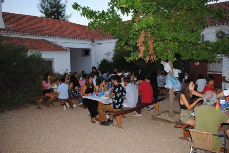 Grupo de participantes a jantar na rua durante o campo de férias Páscoa