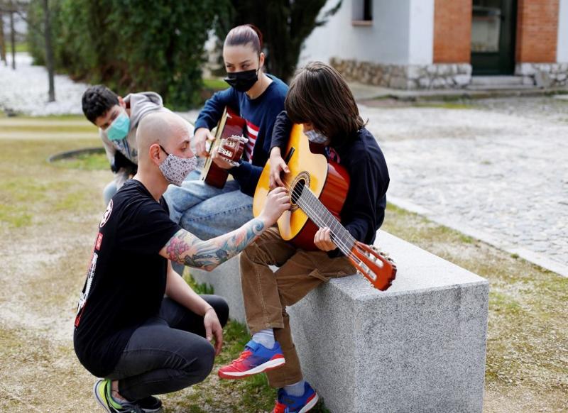 Professor a ensinar os participantes os acordes na guitarra durante o campo de férias de Música