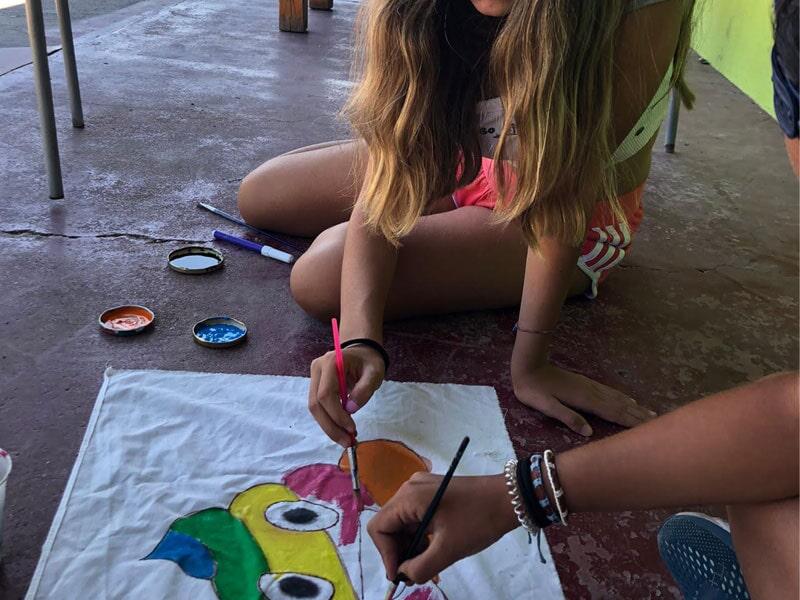 Niña realizando unas manualidades campamento niños con pintura