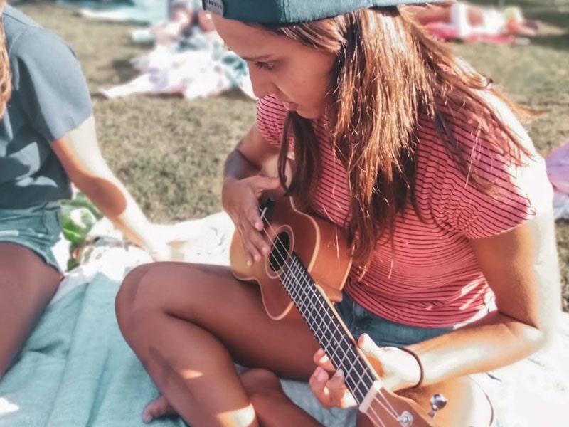 Criança a tocar guitarra na colónia de férias durante o tempo livre
