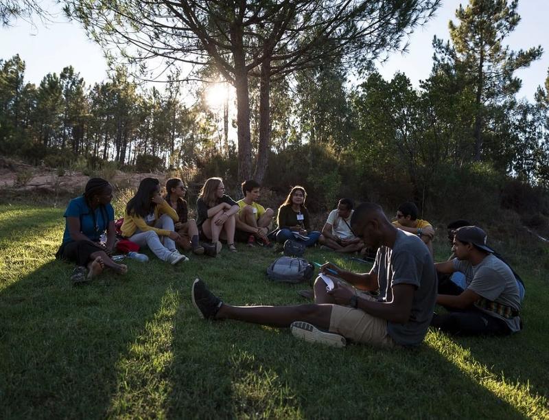 grupo de participantes sentados no jardim em momento de lazer no campo de férias aprender inglês no curso de linguas em portugal 