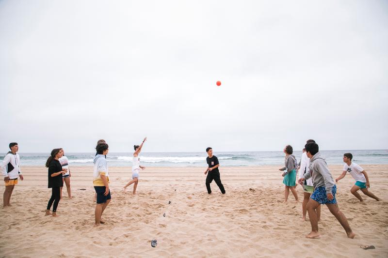 participantes a jogar à bola na praia no campo de férias em Lisboa