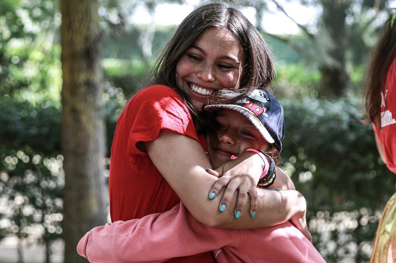 abraço entre uma menina e uma monitora felizes no campo de férias