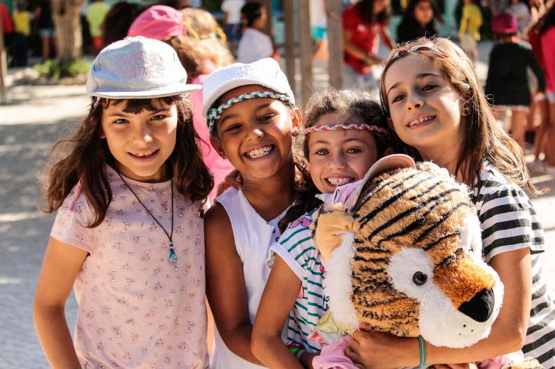 quatro meninas abraçadas a um peluche a sorrirem no curso de linguas em portugal 