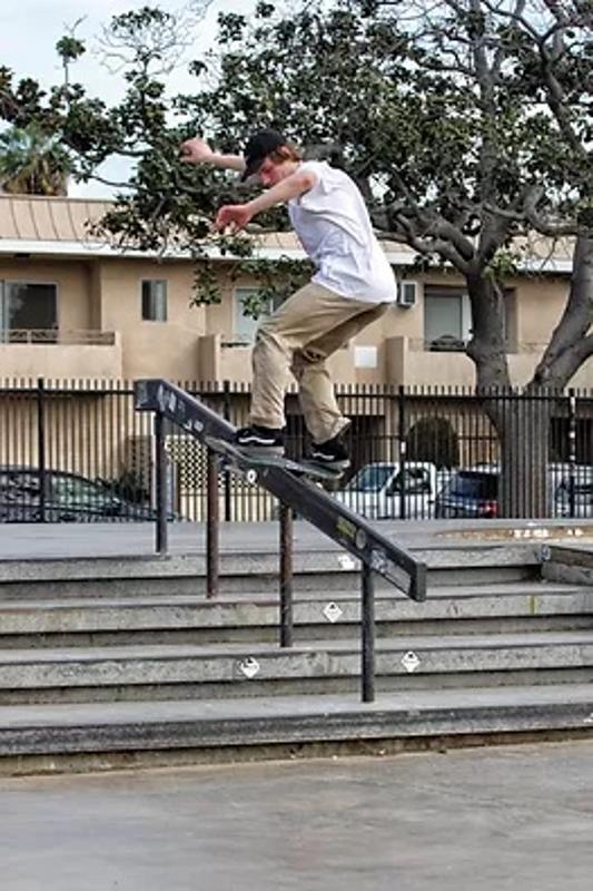 participante a descer um corrimão de skate no summer skate camp