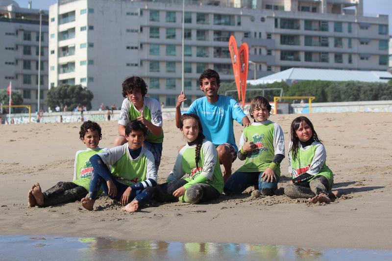 fotografia de participantes sentados no areal depois de aula de surf no Surf camp Porto