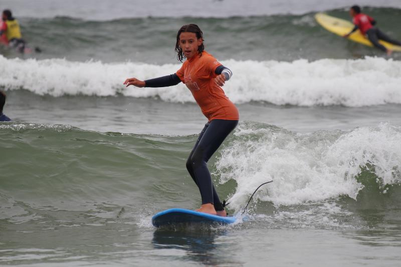 menina a surfar uma onda no surfcamp Porto