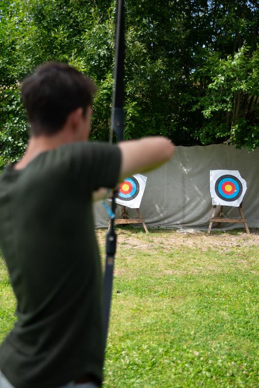 rapaz a fazer tiro com arco no campo de férias aventura
