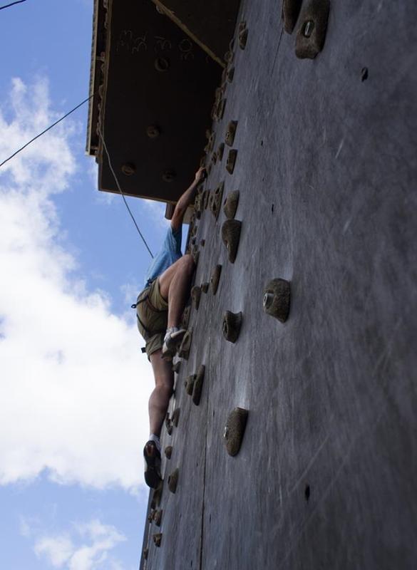 participante a subir uma parede de escalada no campo de férias