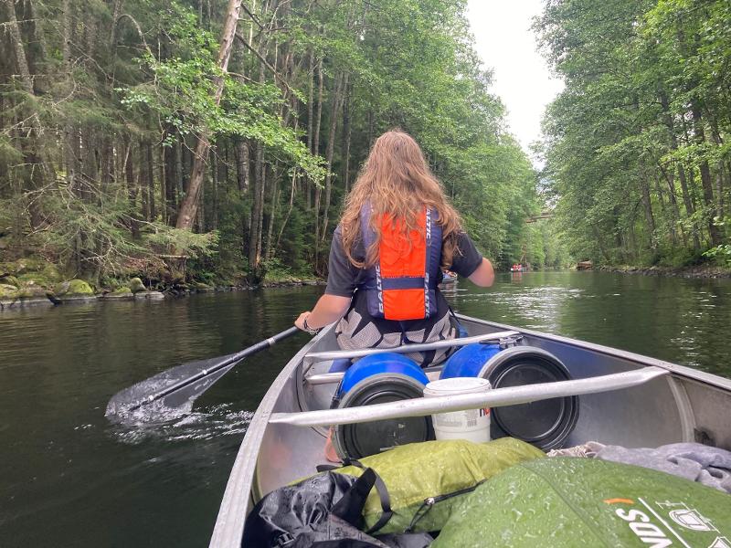 menina a remar a fazer canoagem no campo de férias 