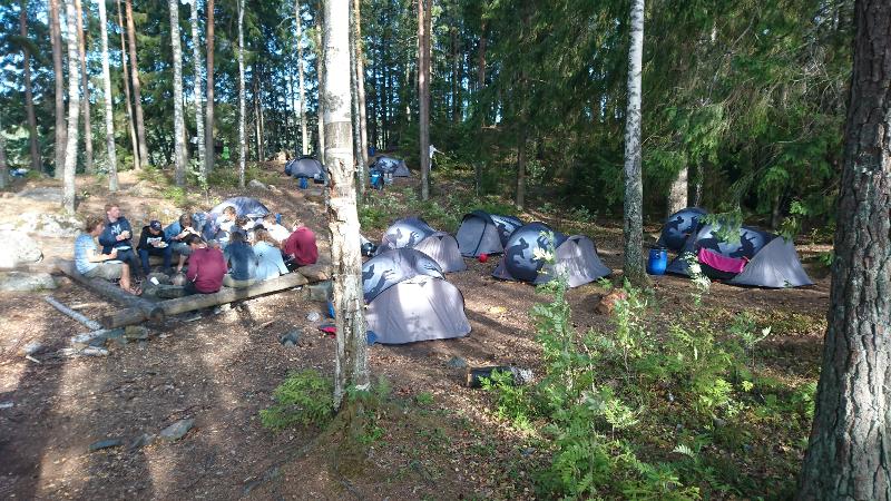 participantes a comer durante o dia de acampamento na floresta no campo de férias aventura