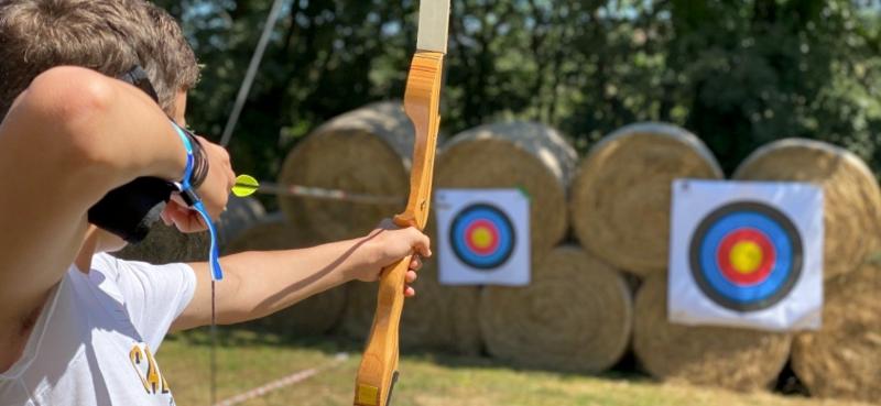 rapaz a fazer atividade tiro com arco no curso de ingles verao