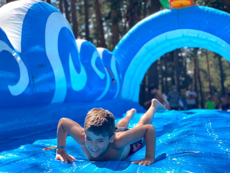 rapaz no escorrega insuflável com água no summer camp activities