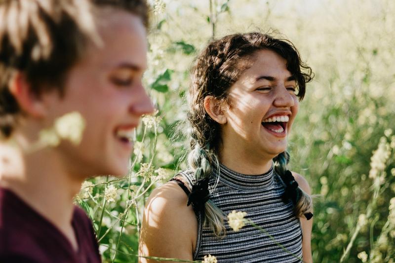 Dois jovens, sorridentes e ao ar livre, desfrutam de um momento descontraído juntos durante o curso de línguas na Alemanha.